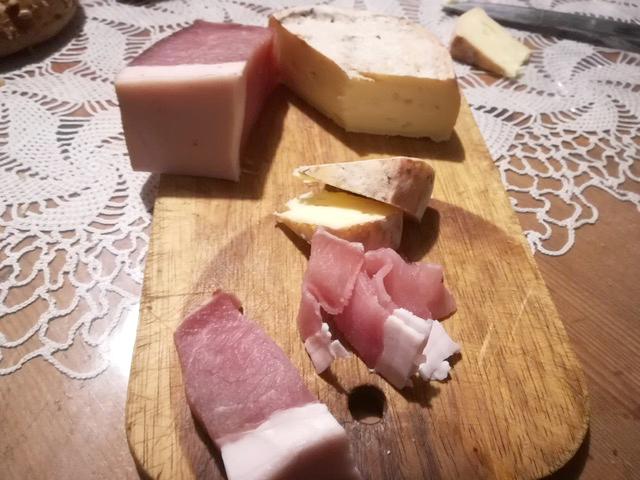 Speck e formaggio fatti in casa su un tagliere di legno